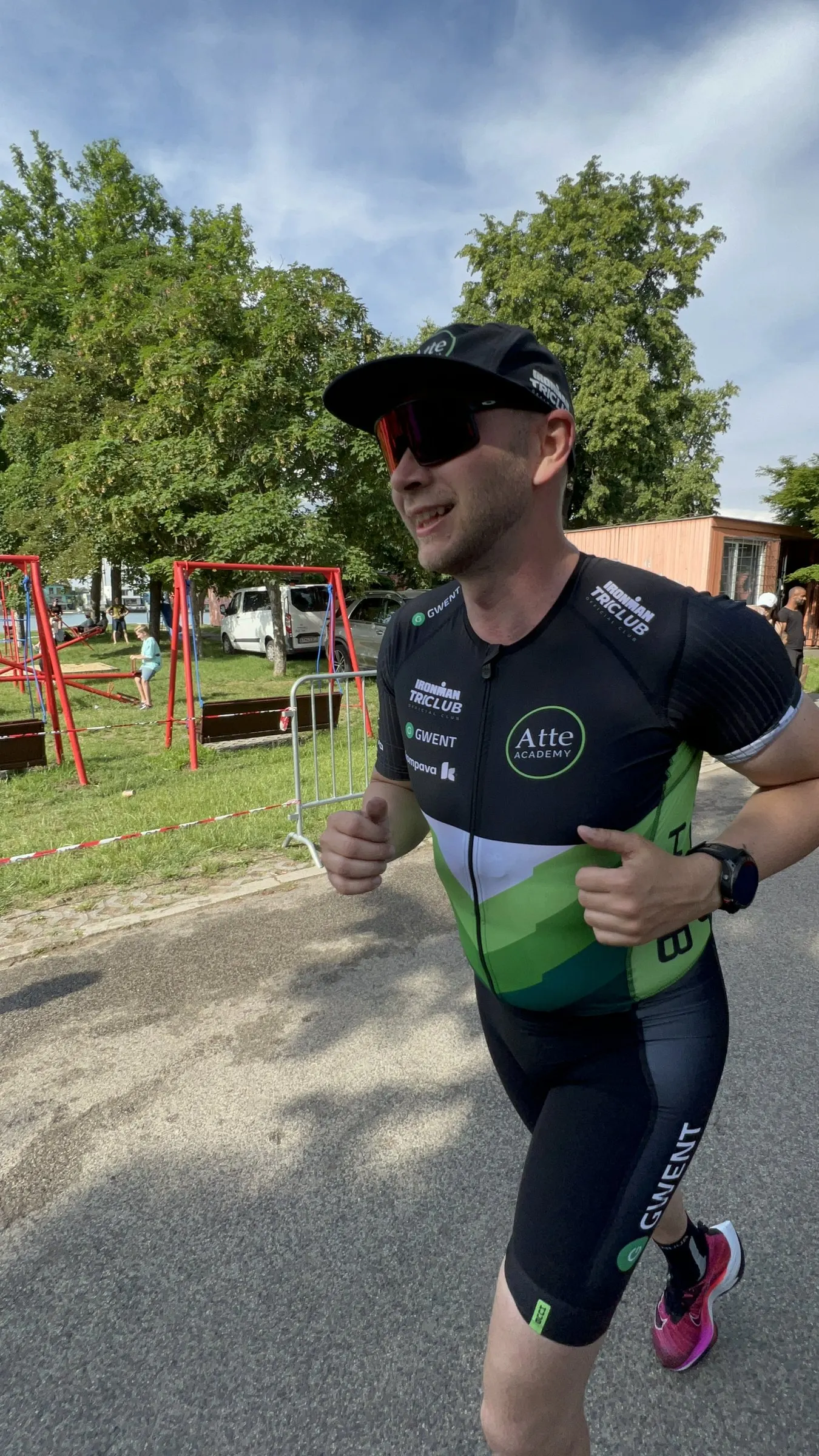 Smiling Atte ACADEMY athlete giving a thumbs-up while running at a race in Senec, Slovakia